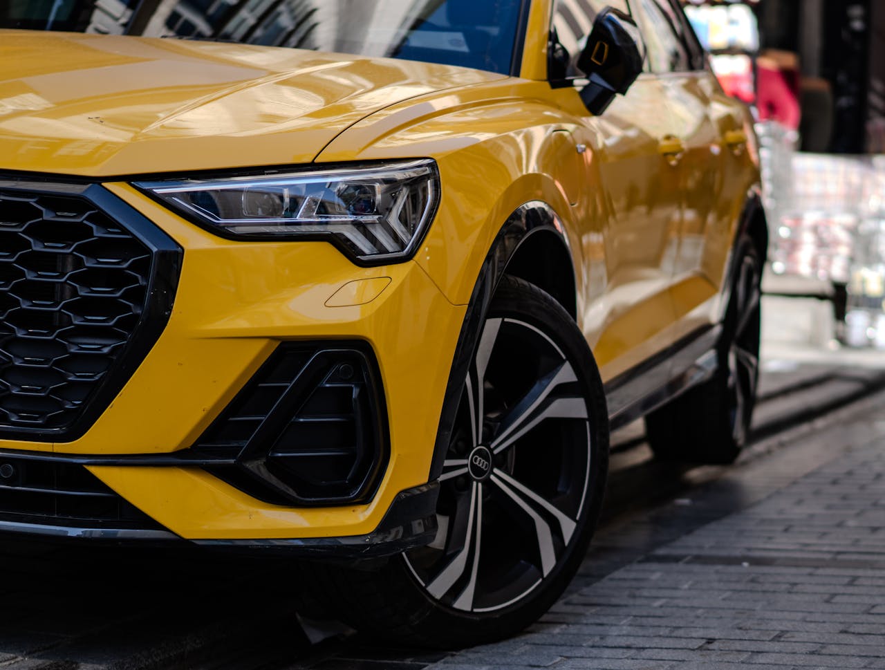 Close-up of a yellow SUV parked on a bustling urban street, showcasing modern design.